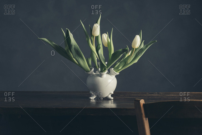 Still life of a vase of tulips on a wood table