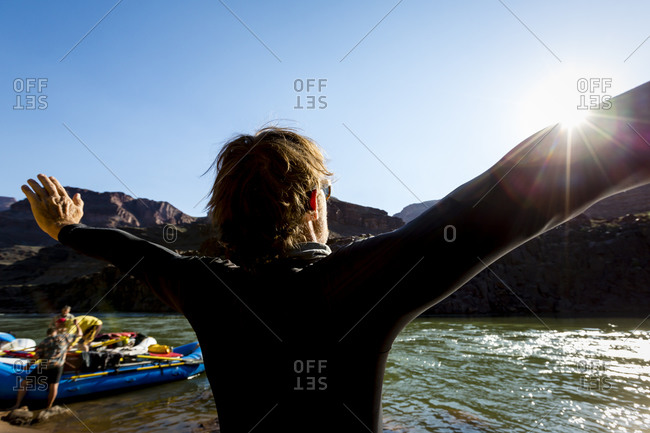 A man greets the sun by the Colorado River
