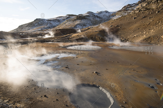 A geothermal pool steams amongst an explosion of earthen colors in Iceland
