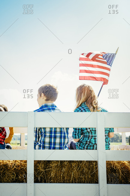 Children waving American flag on hay ride