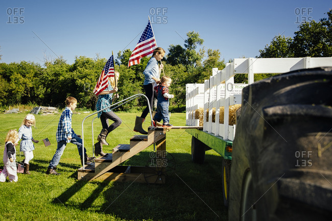 Children climbing stairs to hay ride on farm