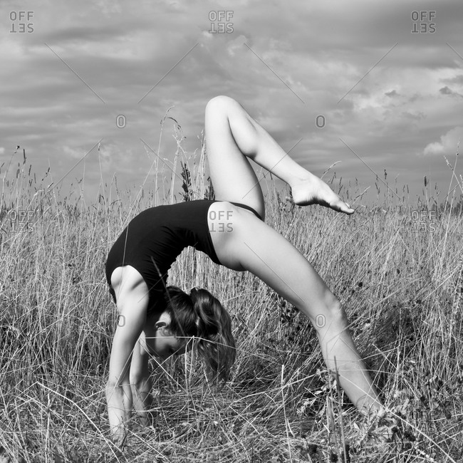 Woman doing backbend in tall grass