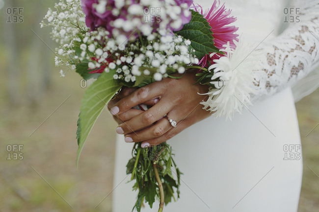 A floral bouquet in a bride\'s hands
