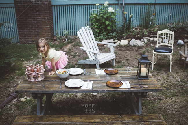 Girl at a picnic table set with plates