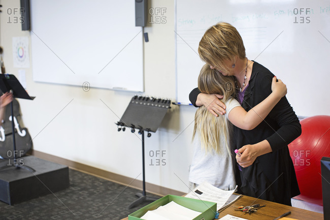 Teacher hugging student in music class