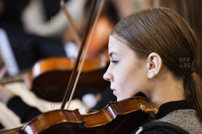 Girl playing violin in orchestra