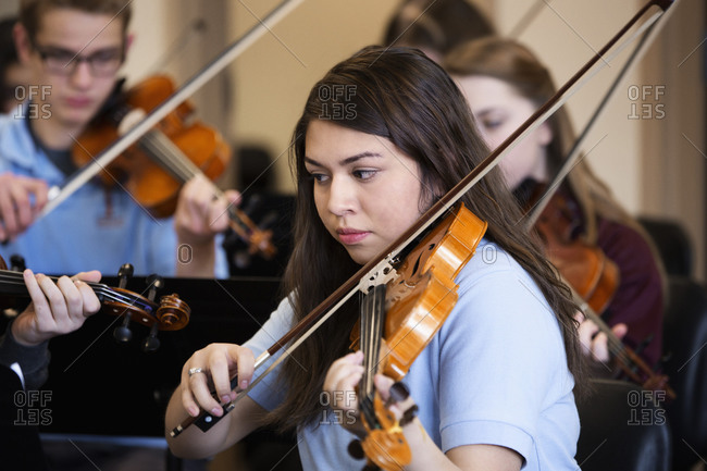 Students playing violin in music class