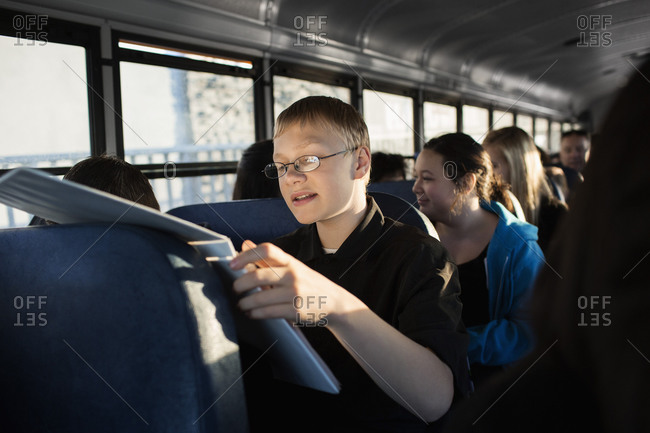 Young boy reading on school bus