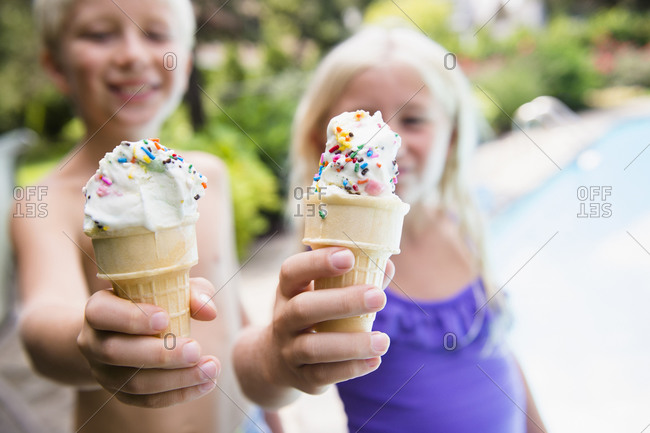 Children eating ice cream near swimming pool