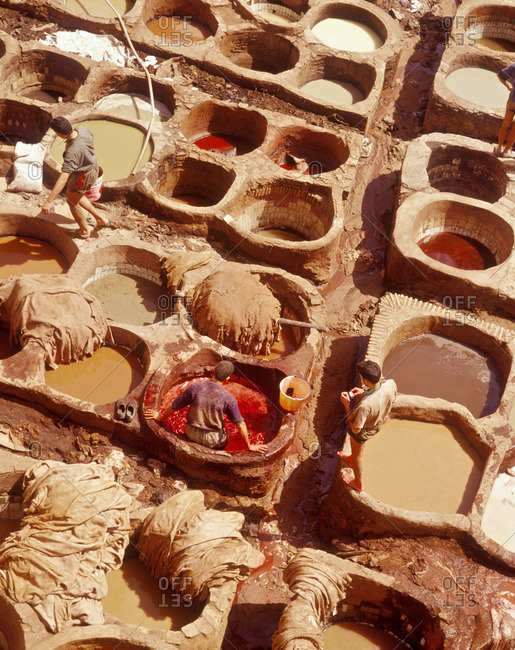 Workers tan leather in pits, Morocco