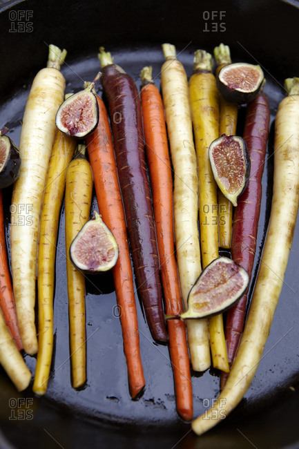Tricolor carrots topped with figs in a cast iron pan