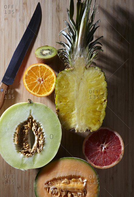 Halved fruit with a knife on a wood table