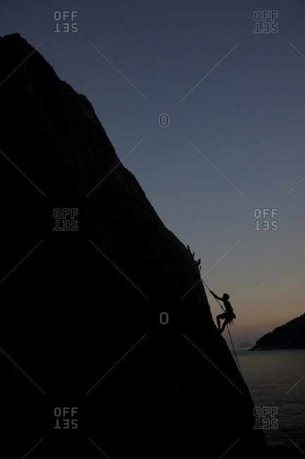 Silhouette of person rock climbing around Sugar Loaf Mountain, Rio de Janeiro, Brazil