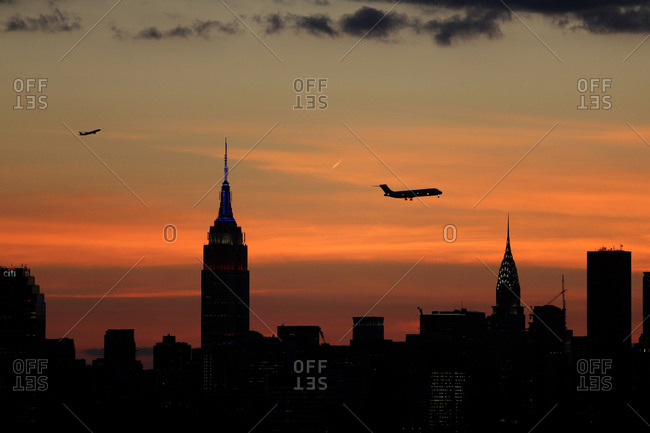 The sun setting behind the Manhattan skyline in New York City viewed from Flushing, Queens, New York