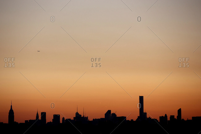 The sun setting in the Manhattan skyline in New York City viewed from Flushing, Queens, New York
