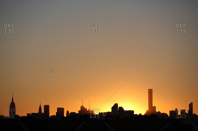 Viewed of the sun setting behind the Manhattan skyline from Flushing, Queens, New York