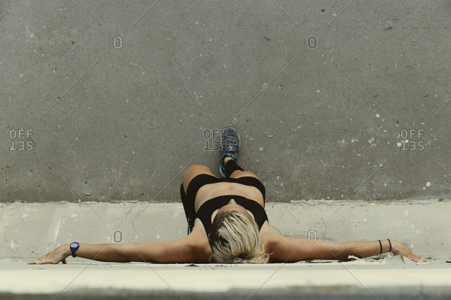 Overhead view of an athletic woman resting against a wall