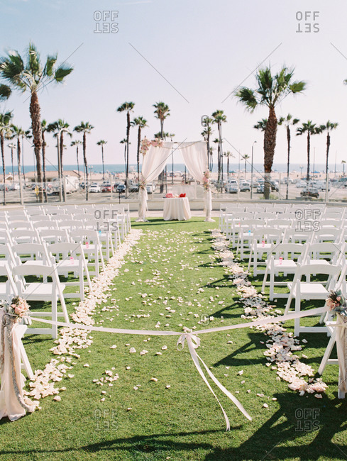 An outdoor wedding staged along a palm covered beach front