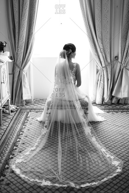 Back view of seated bride with veil spread out on floor behind her