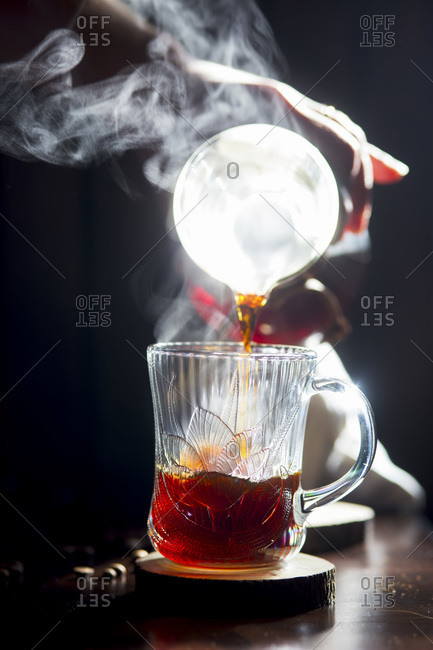 Pouring coffee into a glass coffee cup