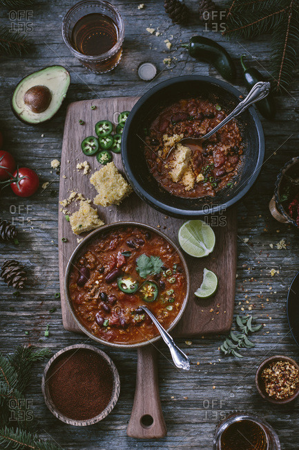 Overhead still life of two bowls of turkey and bean chili and ingredients