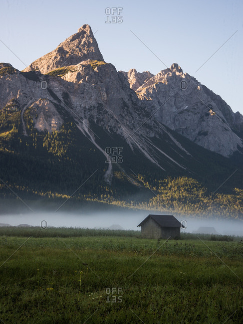 Cabin in a green field in the Bavarian Alps
