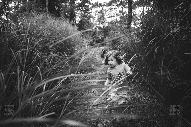 Little girl in black and white running through tall grass