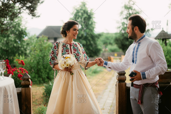 Romanian bride and groom in traditional dress at outdoor wedding