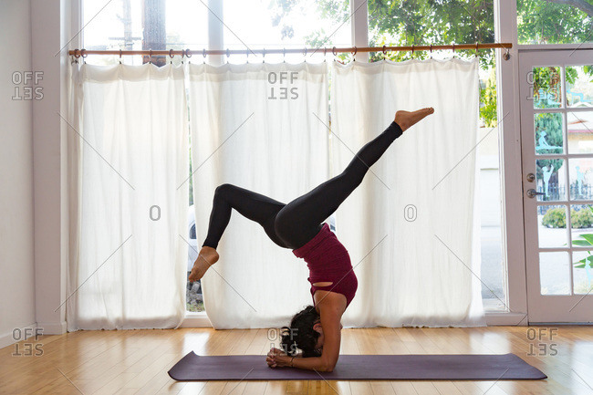 Woman in a yoga studio in a headstand pose