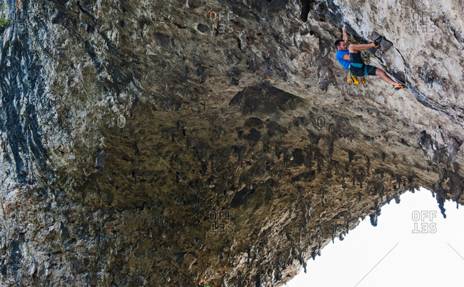 Low angle view of rock climber on Moon Hill, Yangshuo, Guangxi Zhuang, China
