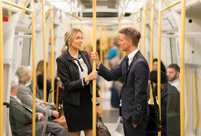 Businessman and businesswoman talking in mass transit