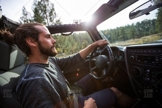 Young man driving suv on road trip, Lake Tahoe, Nevada, USA