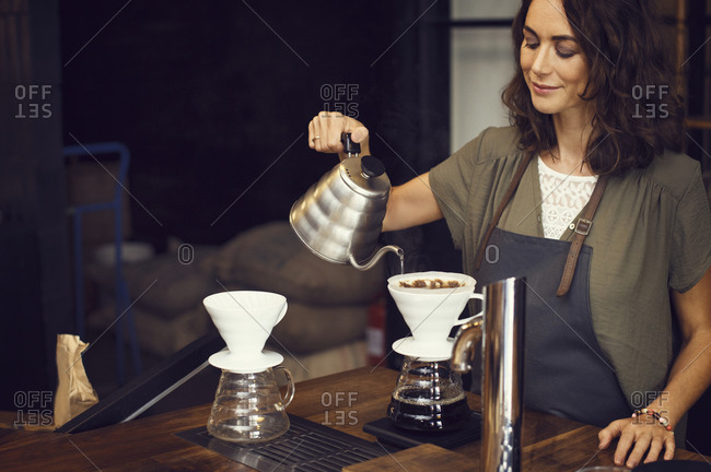 Woman making a cup of pour over coffee in a coffee shop