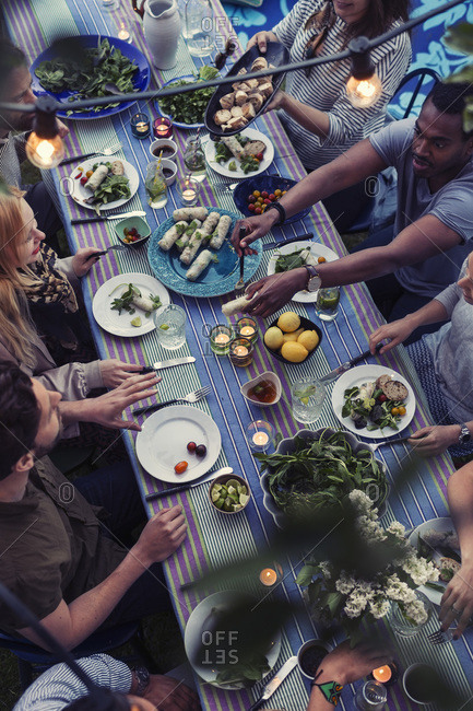 High angle view of friends having food at dining table in yard