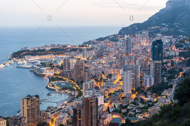 A view of the city of Monaco from a hillside at dusk