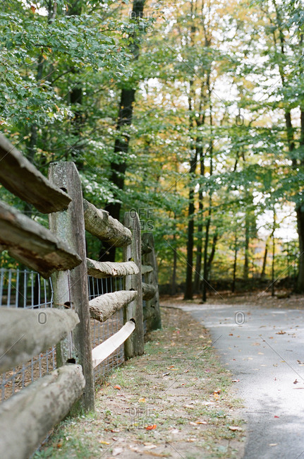 Wood, split rail fence along a wooded path