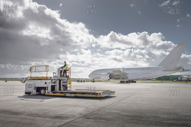 Freight handling machine with an aircraft on runway