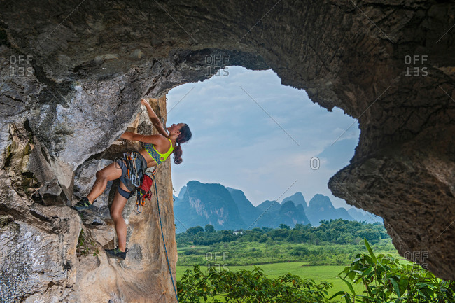 Female climber climbing at the Egg in Yangshuo, Guangxi Zhuang, China