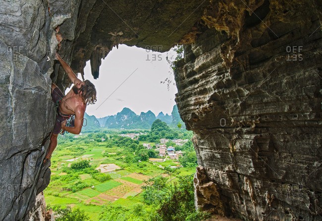 Male climber at treasure cave in Yangshuo, Guangxi Zhuang, China
