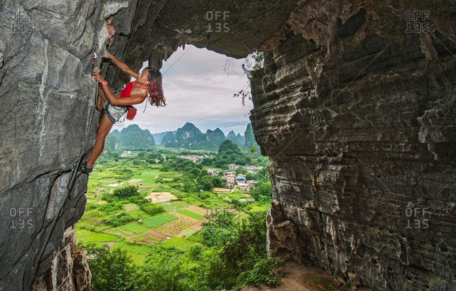 Female climber at treasure cave in Yangshuo, Guangxi Zhuang, China