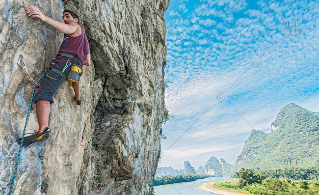 Profile of male climber at Riverside crag in Yangshuo, Guangxi Zhuang, China