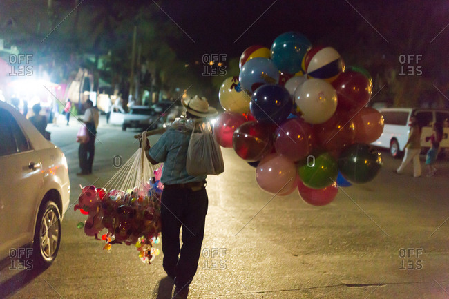 Vendor carrying balloon toys at a street festival