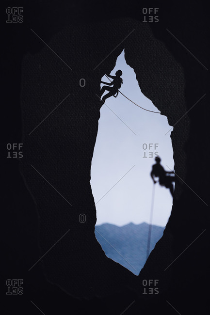 Cardboard cutout of two rock climbers climbing in a cave