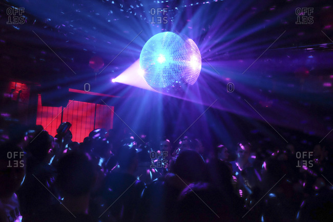 Disco ball and people dancing in a night club