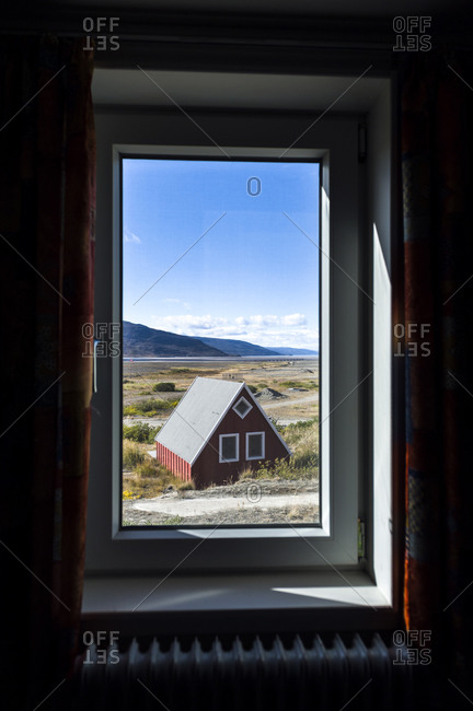 A cottage on the tundra viewed through a weather-sealed window