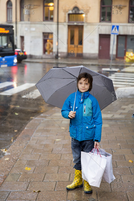 Boy at rain with paper bags