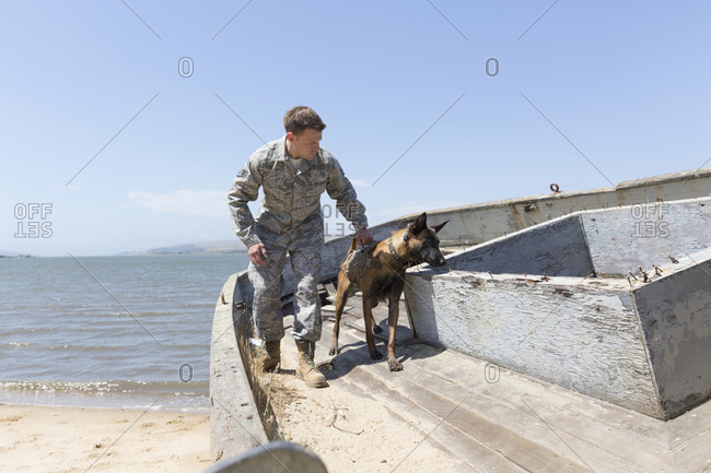 Serviceman training with his Military Working Dog on boat