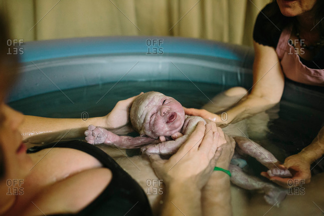 Woman giving birth in pool