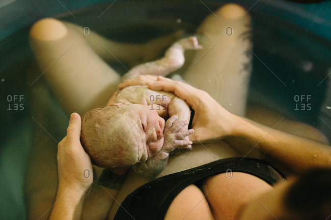 Woman and newborn in birthing pool