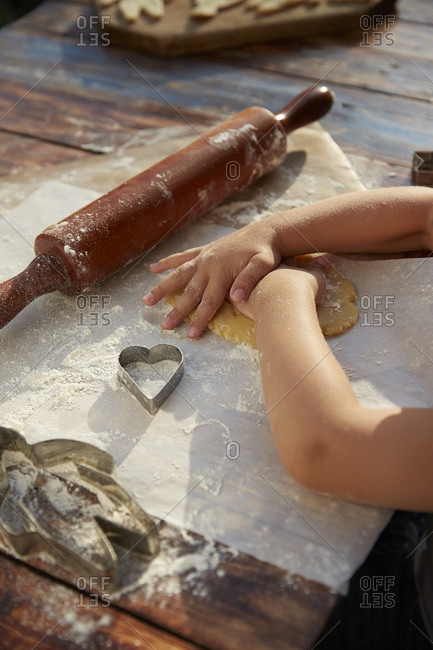 Hands of a boy making cookies at an outdoor table